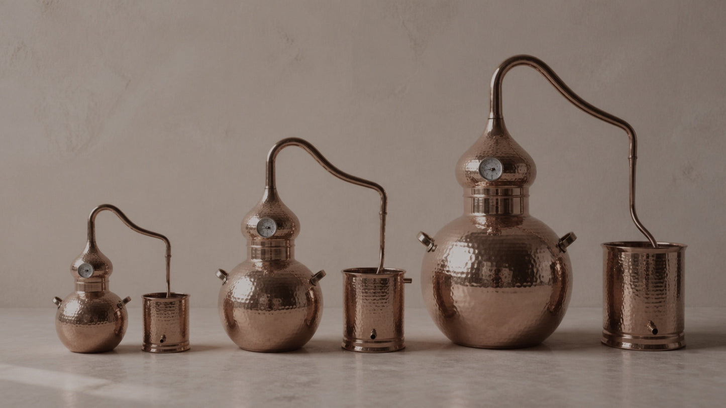 CopperHolic copper alembic stills in all three sizes side by side: 5L, 5 gallon, and 10 gallon
