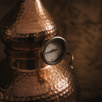 Close-up of the hammered copper dome and built-in thermometer on a CopperHolic alembic still